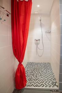 a bathroom with a shower with a red shower curtain at Appartement Sun GroupamaLyon Eurexpo in Meyzieu