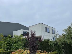 a white house with a garden in front of it at Klein Vloethemnest in Zedelgem