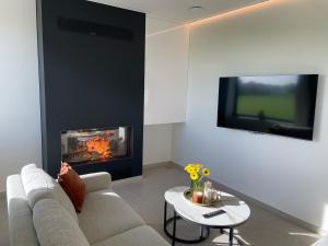 a living room with a couch and a fire place at Klein Vloethemnest in Zedelgem