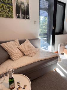 a bed with a bottle of wine on a table at Rogla Gaber Studio in Zreče