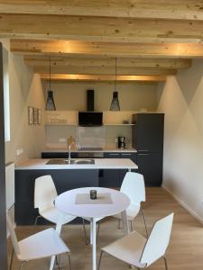 a kitchen with a white table and white chairs at Gartenlodge im Grünen in Feuerscheid