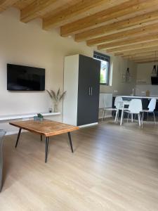 a living room with a table and a refrigerator at Gartenlodge im Grünen in Feuerscheid