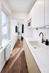 a white kitchen with a sink and a window at Katariina Apartments in Kotka +135 photos
