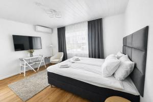 a bedroom with a bed and a desk and a television at Katariina Apartments in Kotka