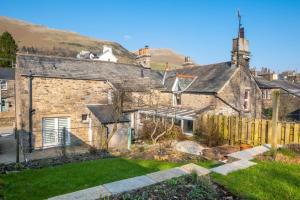 an old stone house with a fence in a yard at 3 Bed in Sedbergh oc-ds960 in Milnthorpe