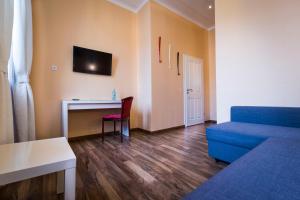 a living room with a blue couch and a desk at Hotel am Markt in Saarburg +41 photos