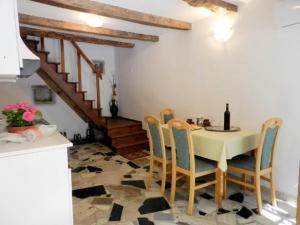 a dining room with a table and chairs and a staircase at House Elena in Lindar