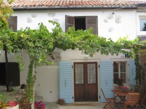a house with blue shutters and a wooden door at House Elena in Lindar
