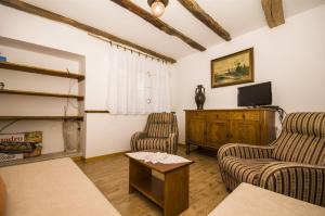 a living room with two chairs and a flat screen tv at House Elena in Lindar