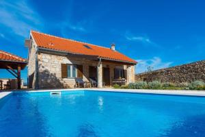 a villa with a swimming pool in front of a house at Villa Rural wellness in Validžići