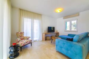 a living room with a blue couch and a chair at Villa Eni in Primošten