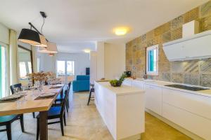 a kitchen with a long table and a dining room at Villa Eni in Primošten