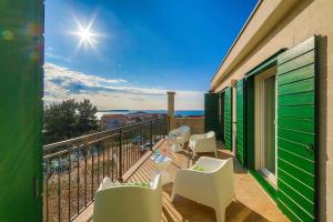 a balcony with chairs and a table on a balcony at Villa Eni in Primošten