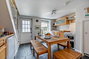a kitchen with a wooden table and wooden chairs at 2 Bed in Edmonton oc-p00586 in Wadebridge