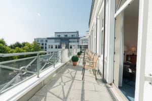 a balcony with chairs and a view of a building at Hotel Arkadia in Friedrichsdorf