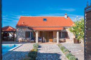 a stone house with an orange roof at Villa Rural wellness in Validžići