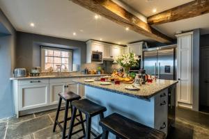 a kitchen with white cabinets and a large island with bar stools at 5 Bed in Padstow oc-p00595 in Padstow