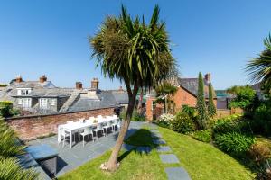 a garden with a table and a palm tree at 5 Bed in Padstow oc-p00595 in Padstow