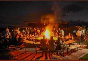 a group of people sitting around a fire at night at Sauron Adventure in Cuesta Blanca