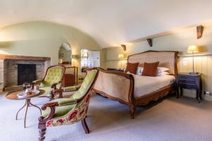 a bedroom with a bed and chairs and a fireplace at 5 Bed in Padstow oc-p00595 in Padstow