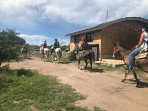 a group of people riding horses in front of a building at Sauron Adventure in Cuesta Blanca