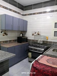 a kitchen with blue cabinets and a stove at Guest house science W 1 in Marsa Alam City