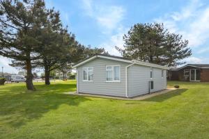 a small white shed in a yard with trees at 2 Bed in Padstow oc-p00551 in Saint Merryn