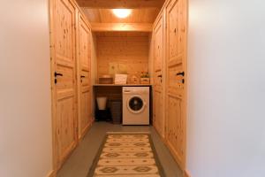 a laundry room with wooden cabinets and a washing machine at Förland Sunnemo in Sunnemo