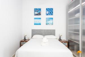 a bedroom with a bed and two pictures on the wall at Apartamento Encanto Gaditano con Terraza by Cádiz Time in Cádiz