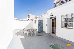 a patio with a table and chairs on a white building at Apartamento Encanto Gaditano con Terraza by Cádiz Time in Cádiz