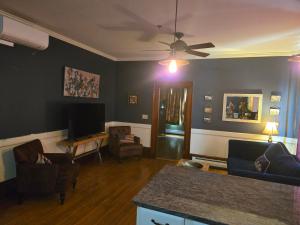 a living room with chairs and a ceiling fan at Firehouse Inn in Barre