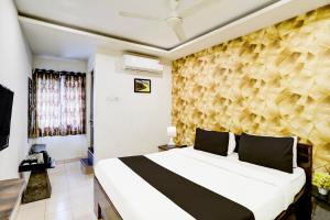 a bedroom with a large bed and a wall at Super Collection O Hingna Road in Nagpur