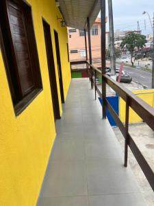 a yellow building with a sidewalk next to a street at Pousada Água Viva in Maceió