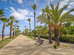 a park with palm trees and a bench at Occidental Mar Menor in Cartagena
