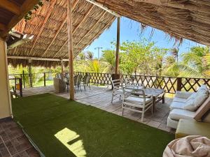 a patio with a table and chairs and grass at Paradise BH in Maizal