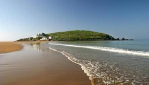 a view of a beach with a hill in the distance at The Hen House in North Huish