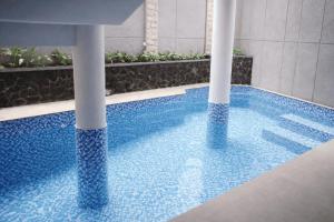 a swimming pool with blue water in a building at Miracle Hotel Cianjur in Pasirhayam