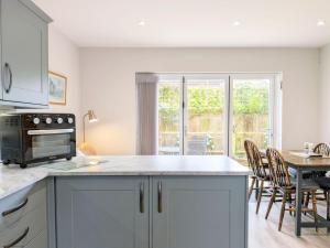 a kitchen with a table and a dining room at Pears Grove - Southbourne in Emsworth