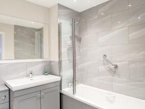a white bathroom with a shower and a sink at Pears Grove - Southbourne in Emsworth +22 photos