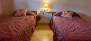 two beds sitting next to each other in a room at CASA TEMPORADa 2027 DÚPLEX 2 HABITACIONES in Miramar