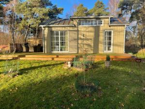 ein kleiner Schuppen in einem Hof mit Rasenfläche in der Unterkunft Hamngardi in Stånga