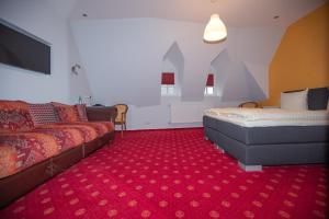 a hotel room with a bed and a couch at Hotel am Markt in Saarburg