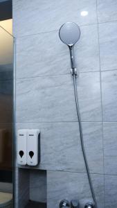 a shower head in a bathroom next to a wall at Miracle Hotel Cianjur in Pasirhayam +20 photos