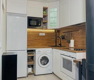 a kitchen with a washing machine and a microwave at Apartamento en la playa con piscina - Azcona 6004 in Noja