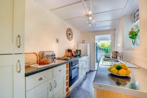 a kitchen with white cabinets and a counter with fruit on a plate at 2 Bed in Bodmin oc-p00429 in Saint Teath