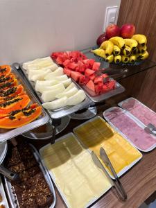 a buffet with many different types of cheeses and fruit at Pousada Recanto do Mar in Navegantes
