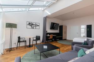a living room with a couch and a table at Hotel Arkadia in Friedrichsdorf