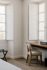 a dining room with a wooden table and a chair at Boutique Hotel NOAE by Emerald Stay in Oletta
