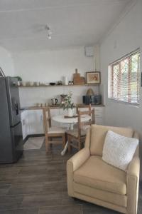 a living room with a couch and a table at Smooth Sailing Unit -Ebbtide Beach House in Port Shepstone