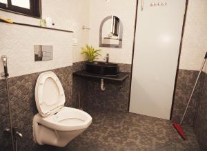 a bathroom with a toilet and a sink at Osho Sumeru K Homestay-Kitchen-Free Parking-Fast Wifi-AC in Mātigara +18 photos